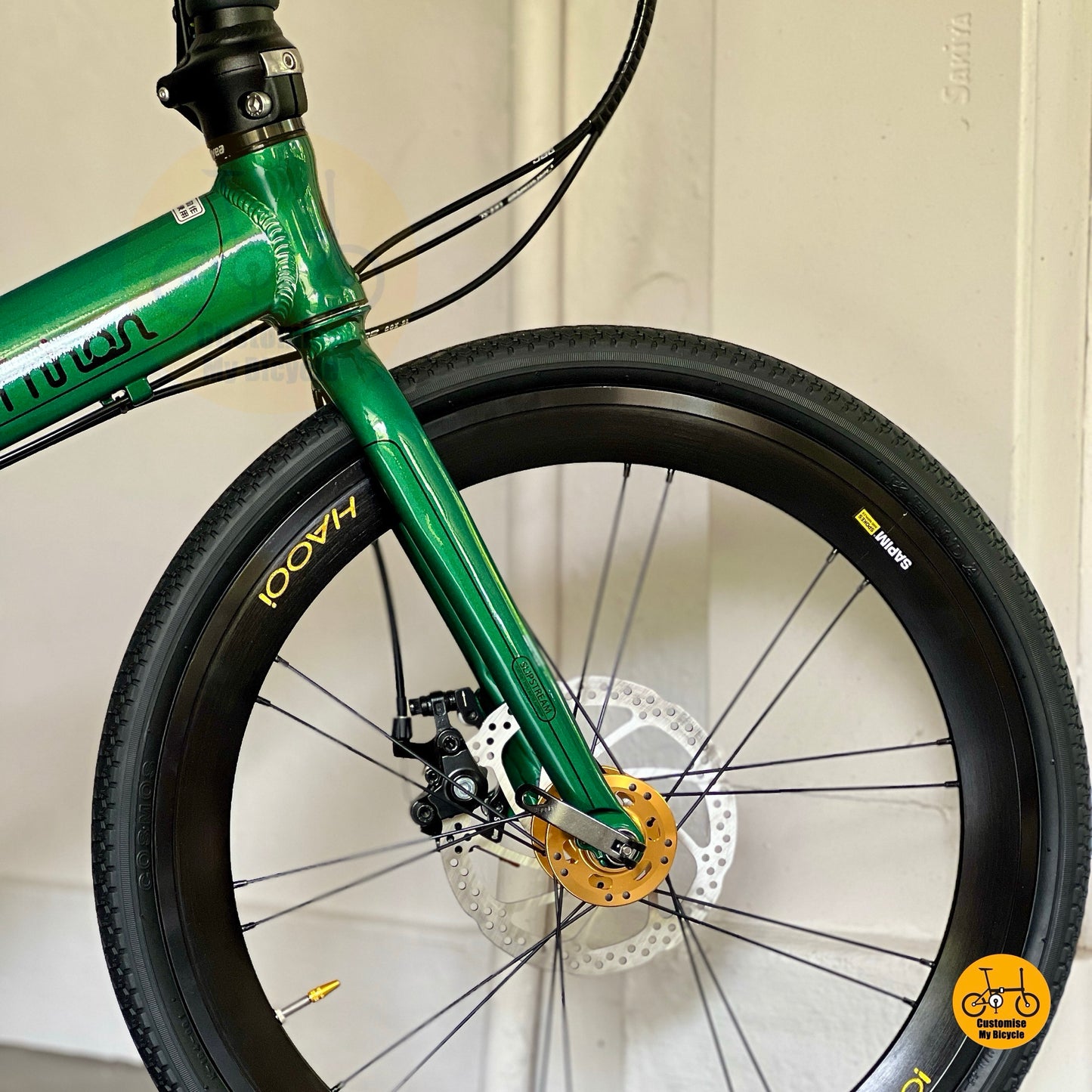 Close up of HAOOI Aero high profile front wheel on Fnhon Monsoon Emerald Green Gold folding bicycle