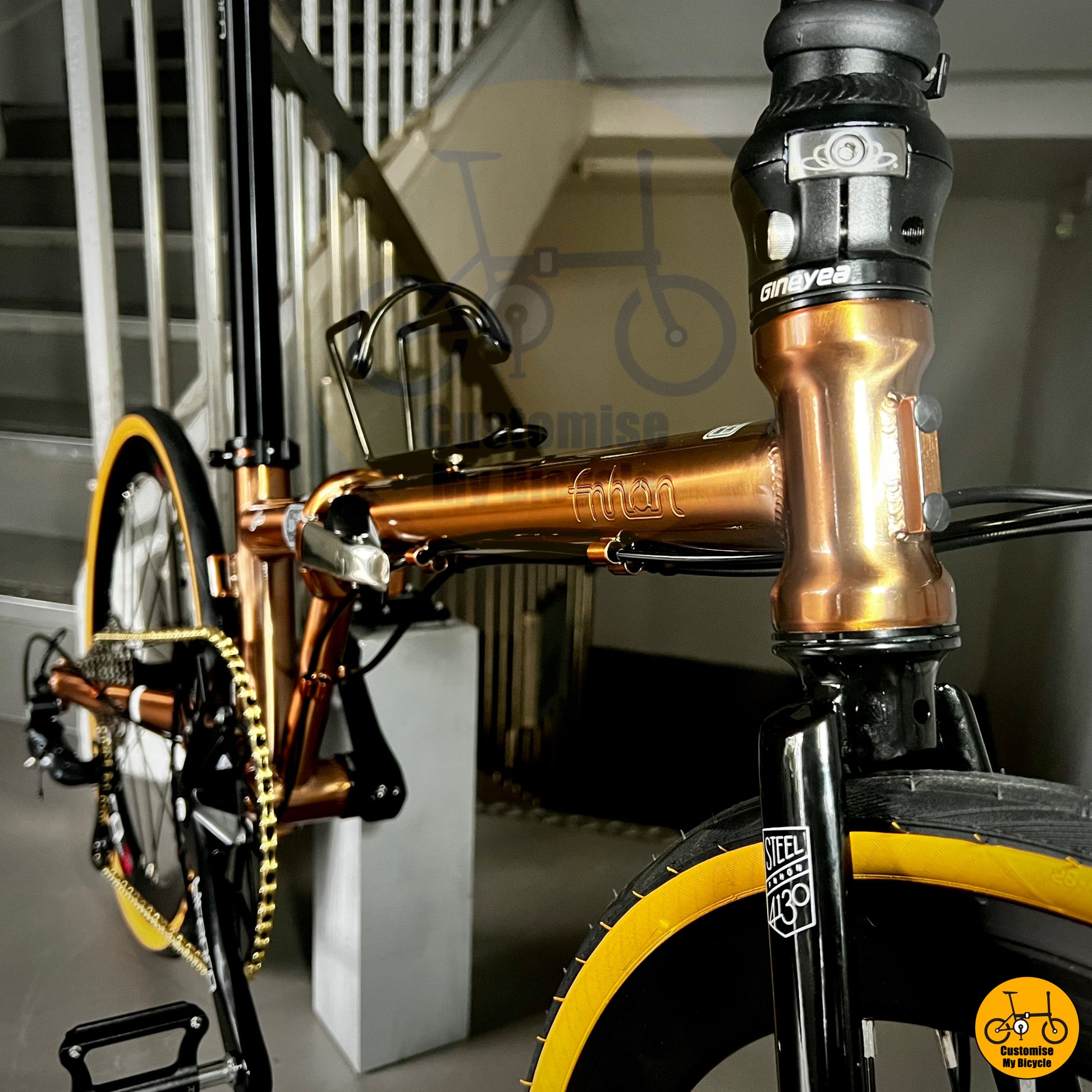 Folding bicycle with a stylish rose gold frame and brown leather saddle
